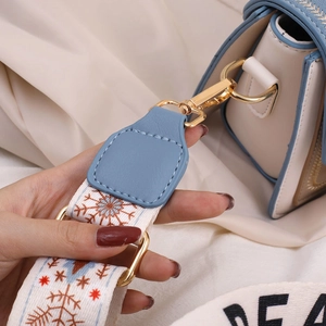 Sac bandoulière bleu clair et crème avec large sangle à flocons de neige et détails dorés