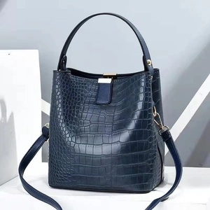 Dark blue crocodile embossed bucket bag with gold hardware and a top handle