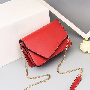 Red leather crossbody bag with envelope flap and gold chain strap on white background