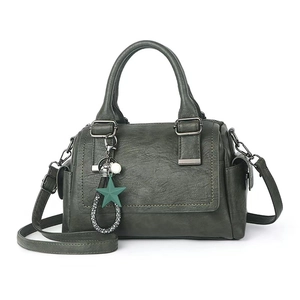Detail of dark green Boston bag showing lychee grain texture and star pendant
