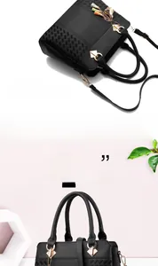Détail du sac à main en cuir grainé noir avec double poignée et pendentif à glands