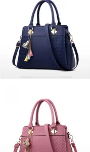 Détail du cuir grainé et du pendentif à fleurs sur des sacs à main spacieux en cuir