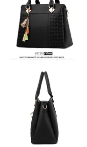 Détail du sac à main en cuir grainé noir avec texture tissée et breloque à pompons colorés