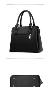 Vue détaillée du sac à main en cuir noir grainé avec zip arrière et pieds en métal doré