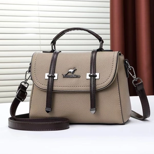 Detailed macro view of beige lychee texture leather handbag with brown handles and metal logo