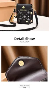 Detail view of the black crossbody bag with gold magnetic snap closure and logo print