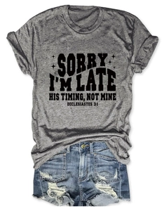 T-shirt gris avec texte et short en jean vieilli disposés à plat sur blanc