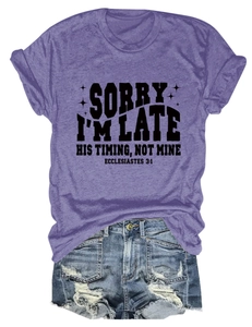 Détail du t-shirt violet à col rond avec texte noir imprimé et manches à revers