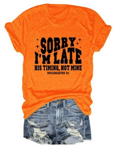 Détail d'un t-shirt orange avec texte imprimé et d'un short en jean bleu délavé