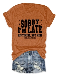 Détail d'un t-shirt orange rouille à col rond avec typographie vintage sur fond blanc