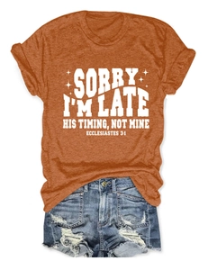 Détail d'un t-shirt orange en coton avec verset biblique et short en jean usé