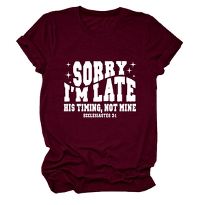Détail d'un t-shirt en coton bordeaux avec texte blanc imprimé 'Sorry I am late'