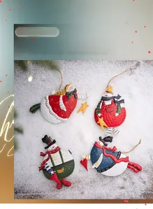 Set of four metal snowman Christmas ornaments with colorful festive patterns and jute ropes