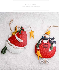 Detail of two painted metal snowman ornaments with rustic textures on snowy background