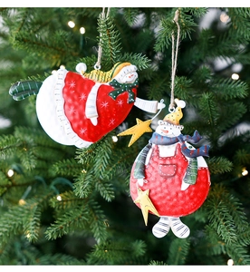 Detail of vintage metal snowman ornaments with hand-painted finish on a Christmas tree