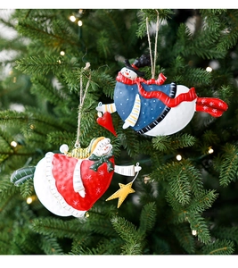 Close-up of colorful metal snowman ornaments hanging on a green Christmas tree