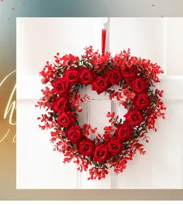 Detailed view of heart-shaped red rose wreath with silk ribbon on white door