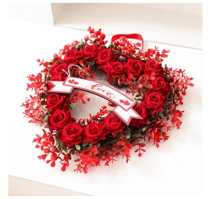 Detail of red rose heart wreath with a Love banner for romantic party wall decor