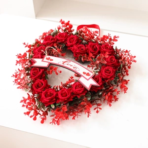 Heart-shaped red rose wreath with Love banner and ribbon for Valentines Day decor