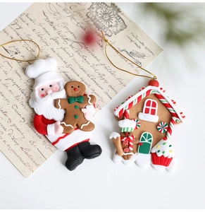 Details von Weihnachtsmann- und Lebkuchenhaus-Anhängern aus Harz mit Goldbändern