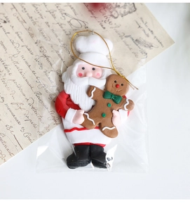 Nahaufnahme vom Weihnachtsmann mit Lebkuchenmann-Anhänger auf Vintage-Papierhintergrund