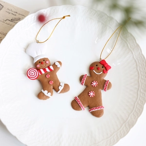 Weihnachts-Lebkuchenmann-Anhänger auf weißem Teller mit goldenen Aufhängern