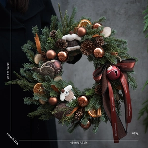 Close-up of a 45cm Christmas wreath with pine cones, cinnamon, and reindeer plush detail