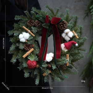 Macro shot of 45cm Christmas wreath with cotton, pine cones, and red velvet bow detail