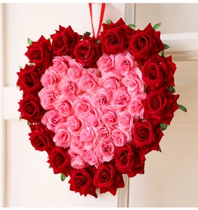 Détail d'une couronne de roses artificielles en forme de cœur avec fleurs roses et rouges