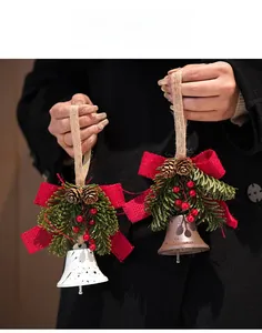 Detail of Christmas bell ornaments with pine cones, red burlap bows and berries