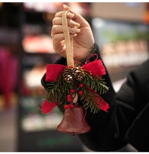 Rustic Christmas bell ornament with red burlap bow, pine cones and berries detail