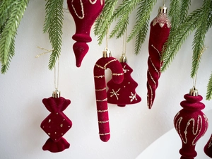Detalle de adornos navideños de flocado rojo con motivos de estrellas doradas