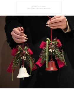 Detalle de campana de Navidad con lazo rojo, piñas y vegetación festiva