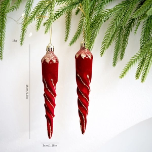 Vista detallada de los carámbanos de Navidad flocados en rojo con purpurina dorada en árbol