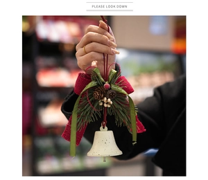 Detalle de campana navideña con lazo de arpillera roja y decoración de piña natural