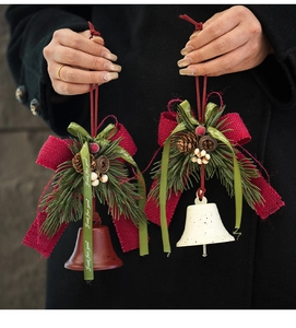 Detalle de campanas de Navidad con piñas y lazos festivos de arpillera roja