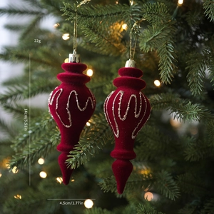 Detalle de adornos navideños flocados rojos en árbol con info de dimensiones y peso