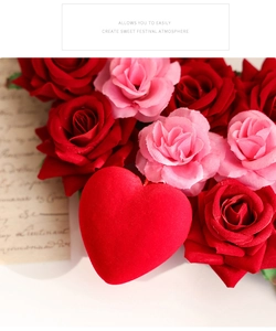 Close-up of velvet red and pink roses with a flocked heart on festive wreath