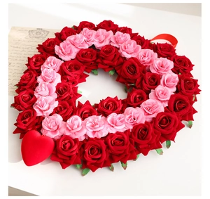 Detail of heart-shaped wreath with red and pink roses, velvet heart, and hanging ribbon