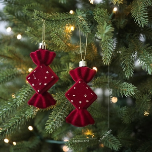 Detalle de adornos navideños de caramelos rojos aterciopelados con lentejuelas blancas