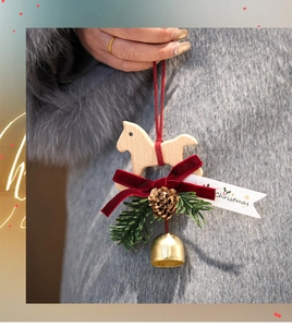 Close-up of wooden rocking horse Christmas ornament with red bow, pine cone and bell