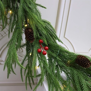Macro view of 2.7m Christmas garland with pine needles, red berries, cones, and LED lights