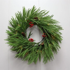 Close-up of LED Christmas garland with green pine needles, red berries and pine cones