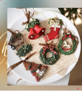 Detalle de adornos navideños de resina con campanas, calcetines y guirnaldas festivas