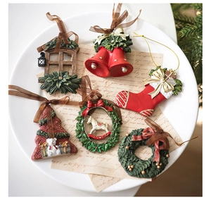 Detalle de adornos navideños vintage de resina con campanas y coronas sobre papel