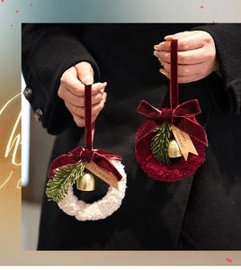 Detail of plush Christmas wreaths with velvet bows and golden bells for tree decoration