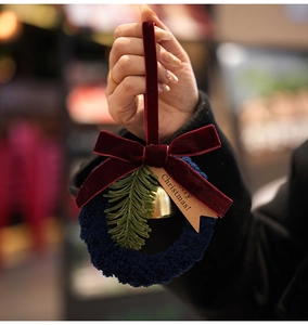 Macro view of blue loop pile ring with red velvet bow and gold bell Christmas ornament