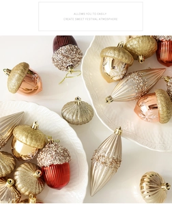 Detail of assorted champagne and burgundy Christmas ornaments in a white ceramic dish