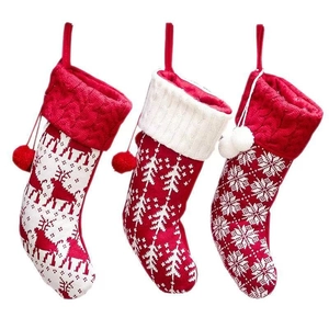 Set van drie rood-witte gebreide kerstsokken met patronen van rendieren en sneeuwvlokken