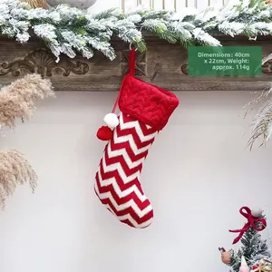 Detail van rood-witte gebreide kerstkous met pompons, afmeting 40x22 cm